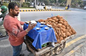 A vendor busy roasting sweet potatoes on his handcart to attract the customers