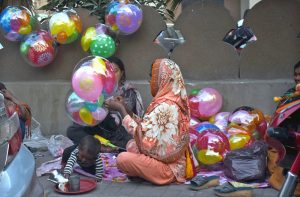 A gypsy family displaying balloons to attract the customers at Safa Wala Chowk.