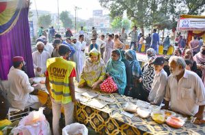 People purchasing grocery items from stalls in Ramazan Bachat Bazaar at Latifabad Unit Number 08 during holy month of Ramazan.