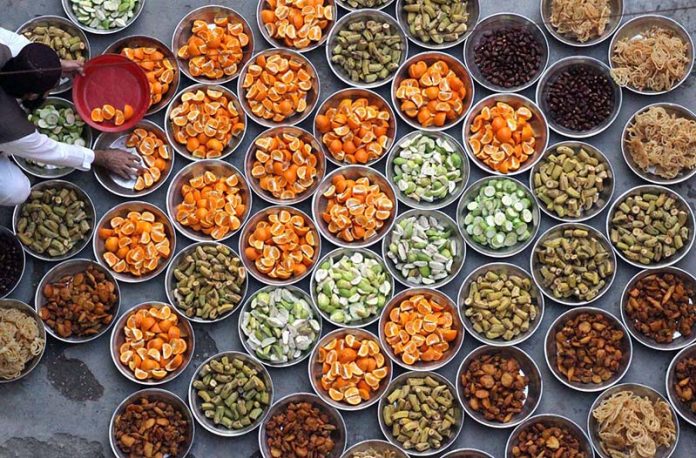 A volunteer arranges Iftar for the faithful to break their fast during the holy fasting month of Ramazan at Madarsa Jamia Ishatul Quran Wal-Hadees, Dodai Road