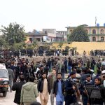 People and security personnel gather at the blast site after a powerful bomb blast at the gate of Tarlai Imambargah killed and injured several people in the Shehzad Town area of the federal capital