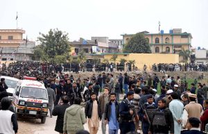 People and security personnel gather at the blast site after a powerful bomb blast at the gate of Tarlai Imambargah killed and injured several people in the Shehzad Town area of the federal capital