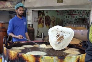 A vendor prepares traditional Pheni fried vermicelli at his shop as demand increases for sehri ahead of the holy month of Ramazan.