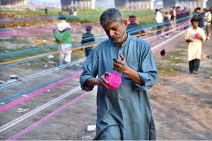 Workers prepare kite-flying string ahead of the upcoming Basant festival in the Provincial Capital