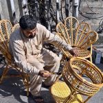 A worker busy paint the furniture at his workplace.