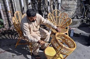 A worker busy paint the furniture at his workplace.