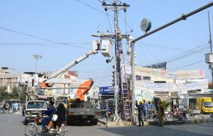 WAPDA workers busy in repairing electric wires on pole during maintenance work at Nawan Shehr.