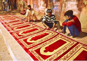 Workers busy in preparing the prayer mats along Radio Pakistan road.