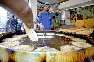 A vendor prepares traditional Pheni fried vermicelli at his shop as demand increases for sehri ahead of the holy month of Ramazan.