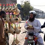 A motorcyclist buys bird nests from a roadside vendor in the city