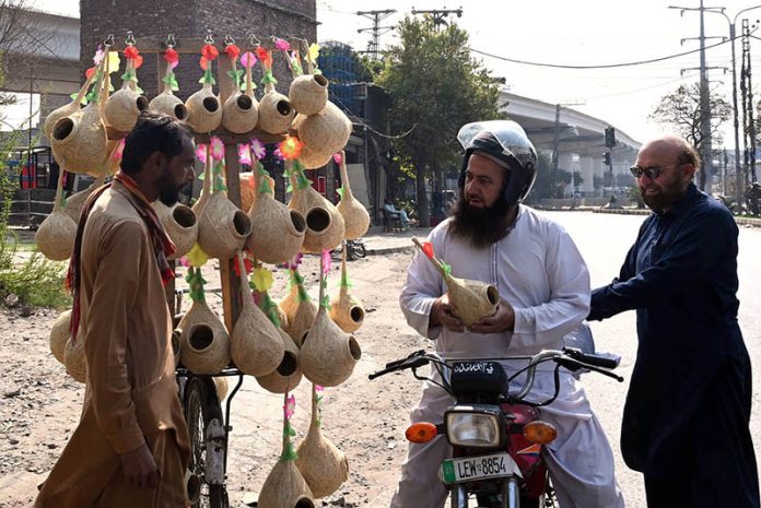 A motorcyclist buys bird nests from a roadside vendor in the city