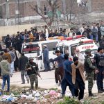 People and security personnel gather at the blast site after a powerful bomb blast at the gate of Tarlai Imambargah killed and injured several people in the Shehzad Town area of the federal capital