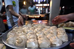 Vendors preparing traditional food stuff (Parathas) for Sehri to the customers at local market during Holy Fasting Month of Ramazan ul Mubarak