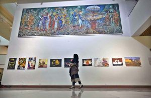 A visitor admires a painting on display during the Art & Craft Exhibition “Silent Expressions II – Dream, Feel and Create,” featuring artworks by students with special needs at the Pakistan National Council of Arts.