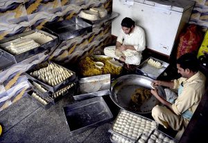 Chefs prepare samosas by filling them with a mixture of chicken mince and potatoes at a local kitchen in Iqbal Colony, twin cities.