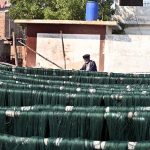 A labourer arranging thread for drying purpose after preparing at local factory.