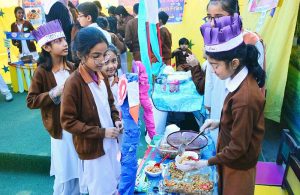 Students serve traditional dishes to visitors at a food stall during a school food festival at RC School.