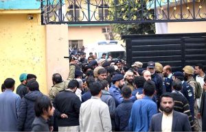 People and security personnel gather at the blast site after a powerful bomb blast at the gate of Tarlai Imambargah killed and injured several people in the Shehzad Town area of the federal capital