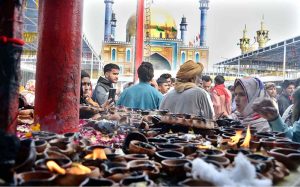 Devotees light oil lamps at shrine of Lal Shahbaz Qalandar on the occasion of 774th Urs celebration