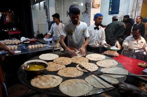 Vendors preparing traditional food stuff (Parathas) for Sehri to the customers at local market during Holy Fasting Month of Ramazan ul Mubarak