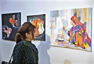 A visitor admires a painting on display during the Art & Craft Exhibition “Silent Expressions II – Dream, Feel and Create,” featuring artworks by students with special needs at the Pakistan National Council of Arts.