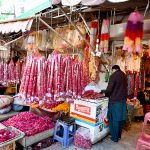 A vendor displaying garlands to attract customers at Bani Chowk.