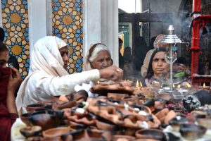 Devotees light oil lamps at shrine of Lal Shahbaz Qalandar on the occasion of 774th Urs celebration