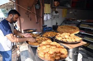 Vendors preparing traditional food stuff (Parathas) for Sehri to the customers at local market during Holy Fasting Month of Ramazan ul Mubarak