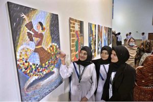 A visitor admires a painting on display during the Art & Craft Exhibition “Silent Expressions II – Dream, Feel and Create,” featuring artworks by students with special needs at the Pakistan National Council of Arts.