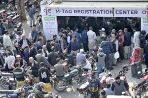 Motorcyclists stand in a long queue at Kachnar Park for mandatory M-Tag registration under the second phase of the capital’s vehicle tagging drive.