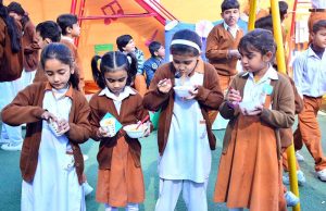Students serve traditional dishes to visitors at a food stall during a school food festival at RC School.