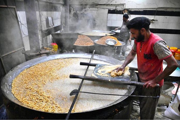 Workers busy in frying traditional food Pakoriyaa mostly used in Dahi Bhalle during the holy fasting month of Ramazan