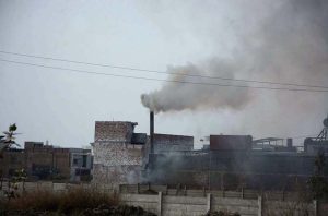 A view of toxic smoke billowing from a factory chimney, polluting the environment and raising concern for the authorities.