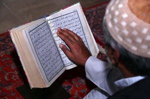 Faithful reciting Holy Quran in a mosque during Holy Fasting Month of Ramzan.