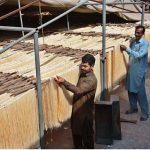 Workers dry vermicelli (sawian) under the sun to meet market demand at his workplace during the holy month of Ramazan.