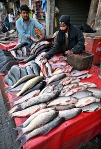 A vendor displays fresh fish pieces to attract customers at the Old Fish Market.