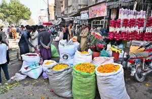 Vendor displaying flower petals to attract the customers in connection with Shab-e-Barat at flower market.