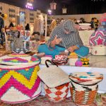 An artisan prepares colorful traditional baskets by hand at a stall during the 2nd day of annual 11th Blue Fair exhibition, organized by Women Chamber Of Commerce.