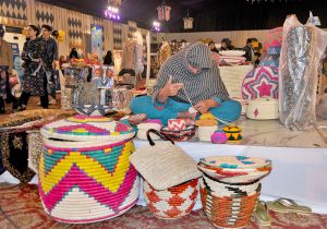 An artisan prepares colorful traditional baskets by hand at a stall during the 2nd day of annual 11th Blue Fair exhibition, organized by Women Chamber Of Commerce.