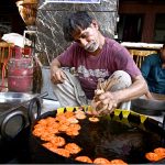 A worker prepares freshly made jalebi, a traditional sweet for iftar, during the holy month of Ramazan at Tower Market