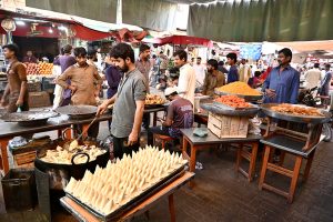A worker prepares freshly made jalebi, a traditional sweet for iftar, during the holy month of Ramazan at Tower Market