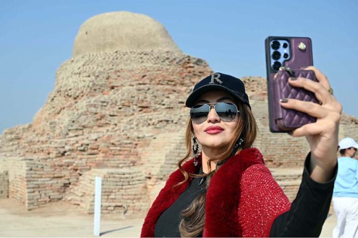 A woman takes a selfie while visiting the world-famous archaeological site of Moen-Jo-Daro as part of the Mohen-Jo-Daro Safari Train delegation by the Sindh Tourism Department