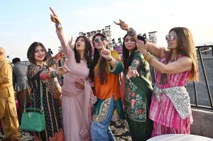 Women enjoys during celebrations of the three-day kite-flying festival “Basant”. The festival has returned to the provincial capital after 20 years