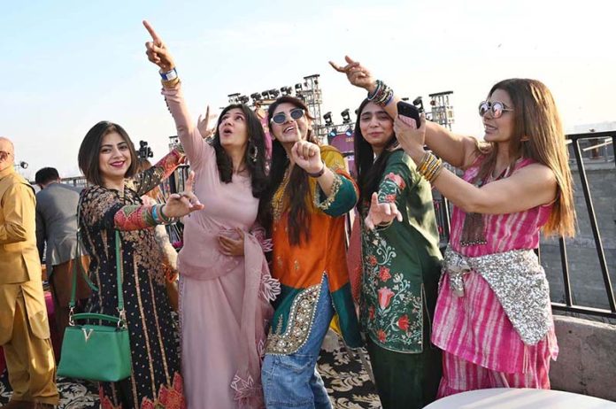 Women enjoys during celebrations of the three-day kite-flying festival “Basant”. The festival has returned to the provincial capital after 20 years