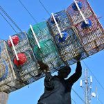 A vendor unloads bird cages from a delivery van near the old fish market.