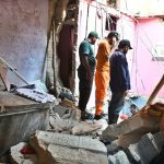 Rescue workers recover a body from the rubble of an apartment building following a gas explosion in Soldier Bazaar