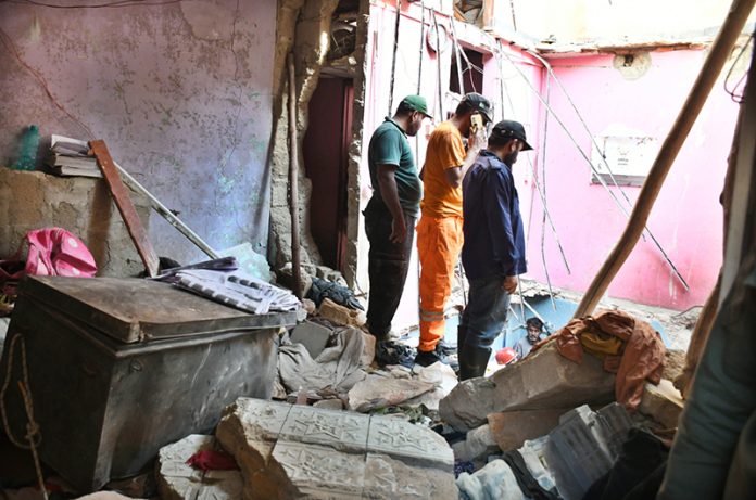 Rescue workers recover a body from the rubble of an apartment building following a gas explosion in Soldier Bazaar