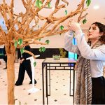 A girl touching an artificial leaf during Pakistan Climate Conference 2026 organized by Overseas Investors Chamber of Commerce and Industry (OICCI) at a local hotel
