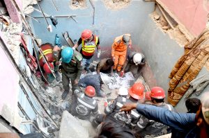 Rescue workers recover a body from the rubble of an apartment building following a gas explosion in Soldier Bazaar