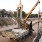 Labourers busy in construction work of flyover of 10th Avenue during development work in Federal Capital
